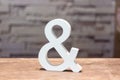 Ampersand & sign on wood table with blurred wall background