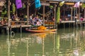 Amphawa Floating Market,Samut Songkhram Province,Thailand on April 13,2019:Buddhist monk rows the boat to receive food offerings f