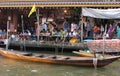 Tourists on the edge of the canal at Amphawa Floating Market