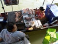 A woman cooks barbecue seafood in a boat while the waitress waits for the order at Amphawa Floating Market Royalty Free Stock Photo