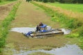 Amphibious harvester clearing weed on waterway