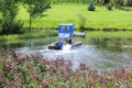 Amphibious machine mowing algae on still water