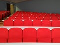 Amphitheater big lecture room with red chairs and white tables for students lined in rows for university or conference lectures Royalty Free Stock Photo