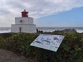 Amphitrite Point Lighthouse at Wild Pacific Trail in Ucluelet with board informing about marine wildlife.