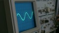 Amplitude Diagram on the oscilloscope. A man presses the buttons on the device. The geometric line changes shape