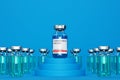 Ampoule with coronavirus vaccine among other ampoules on blue background. concept of 3d test for vaccine against new coronavirus.