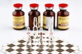 Ampoules on chess board, bottles with medicine Royalty Free Stock Photo
