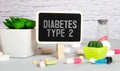 Ampoules, pills, stethoscope, thermometer, tablet with DIABETES TYPE 2 text on desktop