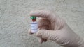 Ampule with coronavirus vaccine in hand with glove