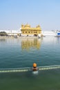 Amritsar, India - February 26 2023 - Unidentified devotees taking holy dip in sarovar at Golden Temple