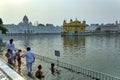 AMRITSAR, INDIA: Sikh devotees bathing or taking a dip in a pool in the Golden Temple Harmandir Sahib in state Royalty Free Stock Photo