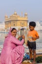 Amritsar, India - November 21, 2011: The Sikh family of pilgrims, mother and son, dresses up a bathing field in the lake in the Royalty Free Stock Photo