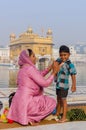 Amritsar, India - November 21, 2011: The Sikh family of pilgrims, mother and son, dresses up a bathing field in the lake in the Royalty Free Stock Photo