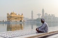 Amritsar, India - November 21, 2011: The Sikh pilgrim meditates on the Amrit Sarovar lake in the Golden Temple complex. Amritsar,