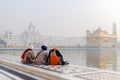 Amritsar, India - November 21, 2011: The Sikh pilgrims meditates on the Amrit Sarovar lake in the Golden Temple complex. Amritsar