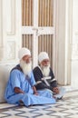 Amritsar, India - November 21, 2011: The Sikh pilgrims meditates on the Amrit Sarovar lake in the Golden Temple complex. Amritsar