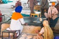 Amritsar, India - November 21, 2011: Unknown Indian people cook national bread for a free meal for pilgrims. Golden Temple in