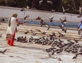 Amritsar Punjab 11-12-2020 lady feeding pigeons while walking on the street