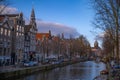 Amstel river, old houses and a bridge. Nice view of the famous city of Amsterdam with boats on the canal Royalty Free Stock Photo
