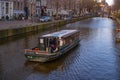 Amstel river, old houses and a bridge. Nice view of the famous city of Amsterdam with boats on the canal Royalty Free Stock Photo