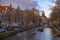 Amstel river, old houses and a bridge. Nice view of the famous city of Amsterdam with boats on the canal Royalty Free Stock Photo