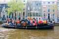 AMSTERDAM-APRIL 27: Crowd of people have dance party on a boat King's Day along the Singel canal on April 27,2015, the Netherlands