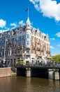 Amsterdam-April 30: Rokin canal with famous Hotel de l'Europe, people cross the bridge on April 30,2015, the Netherlands.