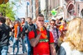 AMSTERDAM-APRIL 27: Undefined person play the pipe, crowd of People have fun on Amsterdam street During King's Day on April