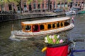 Amsterdam with basket of colorful tulips against boat in Holland