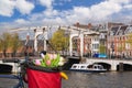 Amsterdam with basket of colorful tulips against canal in Holland