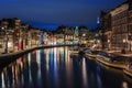 Amsterdam canal, Amstel river with city illumination reflection, Netherlands, Dutch city at night