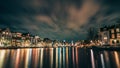 Amsterdam canal, Amstel river with city illumination reflection, Netherlands, Dutch city at night Royalty Free Stock Photo