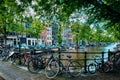 Amsterdam canal with boats and bicycles on a bridge Royalty Free Stock Photo