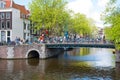 Amsterdam canal with crowd of people and bikes along the bridge during King's Day. Royalty Free Stock Photo