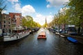 Amsterdam canal with cruise ship with Netherlands traditional house in Amsterdam, Netherlands. Landscape and culture travel, or Royalty Free Stock Photo