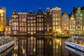 Amsterdam canal houses on the Warmou straat reflected in the water of Damrak Royalty Free Stock Photo