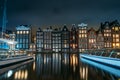 Amsterdam canal Singel with dancing houses and houseboats at night with reflection of illumination in water, Netherlands Royalty Free Stock Photo