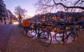 Amsterdam canal view and bicycles on the bridge in evening