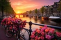 Amsterdam canals with bicycles and flowers at sunset. Holland, Beautiful sunrise over Amsterdam, The Netherlands, with flowers and Royalty Free Stock Photo