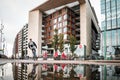 Amsterdam City centre street scene reflected in puddle of water modern apartments building and tourist on bike deserted