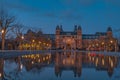 Amsterdam in a cold night during spring season. Famous national Rijks museum general view reflecting in tha water at dusk