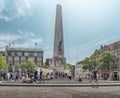 Monument on the Dam Square in the summer, people on the streets shopping
