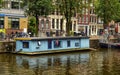 Amsterdam,Holland,August 2019. In the historic center a view that is a symbol of the city: a blue houseboat moored on the edge of