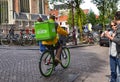 Amsterdam, Holland. August 2019. In the red-light district the old church is a landmark. An uber eats worker goes around with his