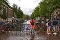 Amsterdam, Holland, August 2019. Typical view over a canal in the historic center. Rainy day. Colorful bikes parked on the railing Royalty Free Stock Photo