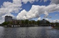 Amsterdam, Holland, August 2019. View of the Amstel River. On the shore boats house, behind the town. Blue sky with soft white Royalty Free Stock Photo