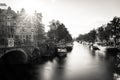 Amsterdam, Holland, the Netherlands - July 6 2020: Bridge over a wide canal, staging a typical canal house with the sun glanzing