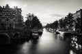 Amsterdam, Holland, the Netherlands - July 6 2020: Bridge over a wide canal, staging a typical canal house with the sun glanzing