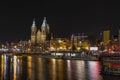 Amsterdam/Holland - October 06 2019: Night city view of Amsterdam canal, Basilica of Saint Nicholas and Barbizon Palace, Royalty Free Stock Photo