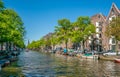 Amsterdam, May 7 2018 - The Prinsengracht with small boats sailing on it and in the background the Westertoren on a sunny day